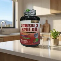 Aceite de krill en cápsulas en la cocina de una casa, junto a un vaso de agua