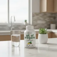 Cápsulas de aceite de orégano en la cocina de una casa, junto a un vaso de agua