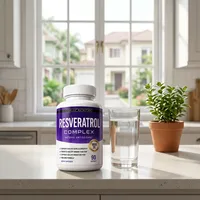 Cápsulas de resveratrol en la cocina de una casa, junto a un vaso de agua