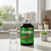 Cápsulas de vitamina E y selenio en la cocina de una casa, junto a un vaso de agua