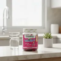 Gomitas de vitaminas para niños en la cocina de una casa, junto a un vaso de agua