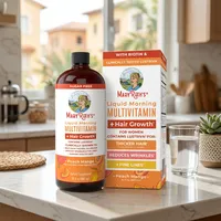 Multivitamínico líquido en la cocina de una casa, junto a un vaso de agua