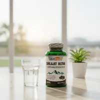 Shilajit en cápsulas en la cocina de una casa, junto a un vaso de agua